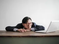 Bored formal man watching laptop at desk 3760811